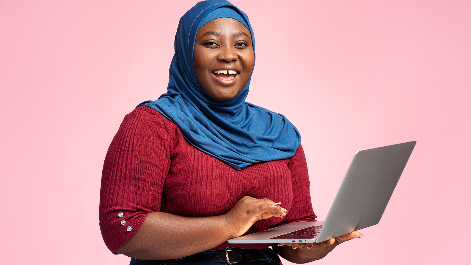 Nigerian woman in tech smiling with open laptop